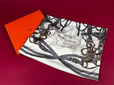 a close up of a scarf on a red surface with an orange box