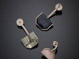 trois bijoux en argent et en or posés sur un fond noir