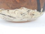a brown and white bowl sitting on a white surface