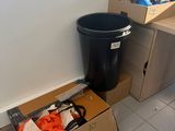 a black trash can and a black trash can in the corner of a room