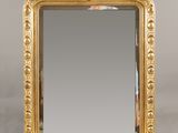 un miroir à cadre doré orné d'un motif décoratif sur le pourtour
