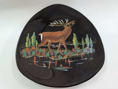 a black plate with a picture of a deer on it