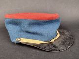 une image représentant un chapeau bleu orné d'un ruban rouge