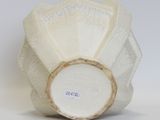 a white vase that has a white flower on it