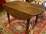 a small table with a wooden top sitting on a rug