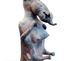 a sculpture of a goat that is sitting on top of a rock