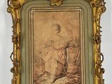 an old picture of a woman sitting in a chair in a gold frame