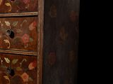 a wooden chest of drawers with a floral design on it