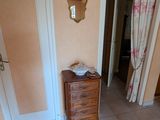 une pièce dans laquelle se trouvent une commode et un miroir