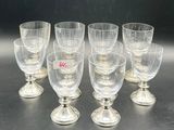 six clear wine glasses sitting on top of a table next to each other