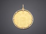 a gold coin pendant with an image of a lion on it