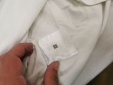 a man that is putting a piece of cloth on his shirt
