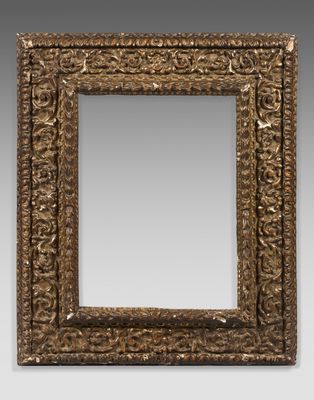 un miroir orné d'un cadre doré au motif décoratif