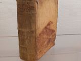an old book sitting on top of a glass table next to a white wall