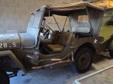 a military jeep parked in a garage next to a building
