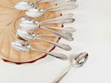 several spoons and spoon rest on a glass plate on a white surface