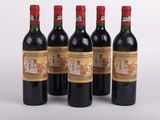 quatre bouteilles de vin sont alignées sur une surface blanche