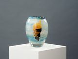 a glass vase with a painting on it sitting on a pedestal