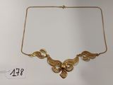 un gros plan d'un collier en or exposé sur une table