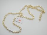 un gros plan sur un collier de perles blanches muni d'une étiquette