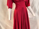 a red dress on a mannequin stand against a white backdrop