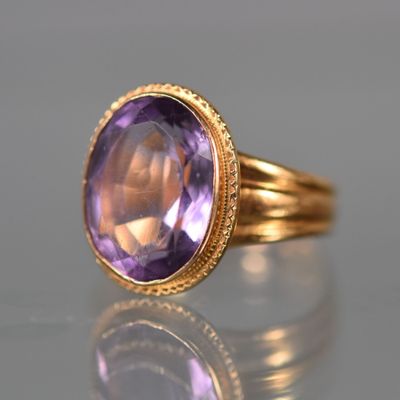 gros plan d'une bague en or avec une pierre en améthorate