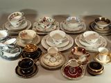 de nombreux types de tasses à thé et de soucoupes sur la table