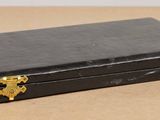 a small black box with gold handles on a table