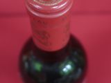 une bouteille de vin posée sur une surface rouge