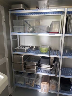 un garde-manger avec beaucoup de provisions et de vaisselle sur les étagères