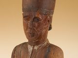 an old wooden statue of a man with a hat on