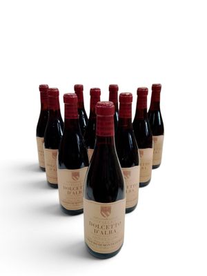 six bouteilles de vin sont alignées sur une surface blanche