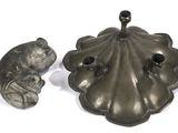 two metal objects that are sitting on a white surface
