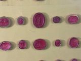 a lot of pink wax seals on a yellow surface