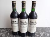 trois bouteilles de vin posées sur une table l'une à côté de l'autre