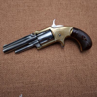 an old revolver with a wooden handle on a brown surface