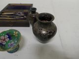 a small vase sitting next to a small box on a table