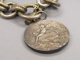 une pièce de monnaie attachée à une chaîne, elle-même entourée d'une chaîne