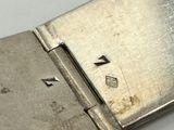 a close up of a silver watch on a white surface