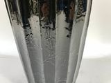 a black vase that is sitting on a white surface