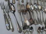 a lot of spoons and forks laid out on the table