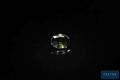 gros plan d'une pierre précieuse verte sur une surface noire