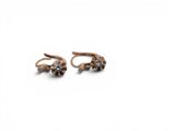 a pair of gold and diamond earrings on a white background