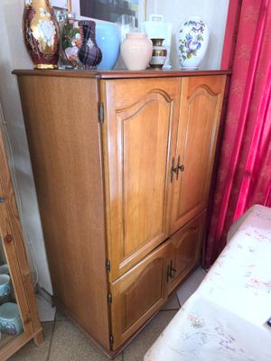 une armoire en bois et un miroir dans un coin de la pièce