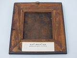 an old picture frame with a label on it on a white surface