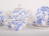 several pieces of blue and white porcelain tea set on a white surface