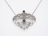 un collier en argent orné d'une pierre noire et de diamants blancs
