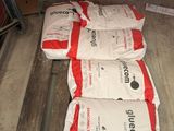 trois sacs de ciment posés sur une palette