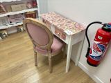 a fire extinguisher next to a desk with a chair
