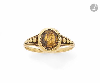une bague en or sur laquelle sont gravés le visage d'une femme et celui d'un homme